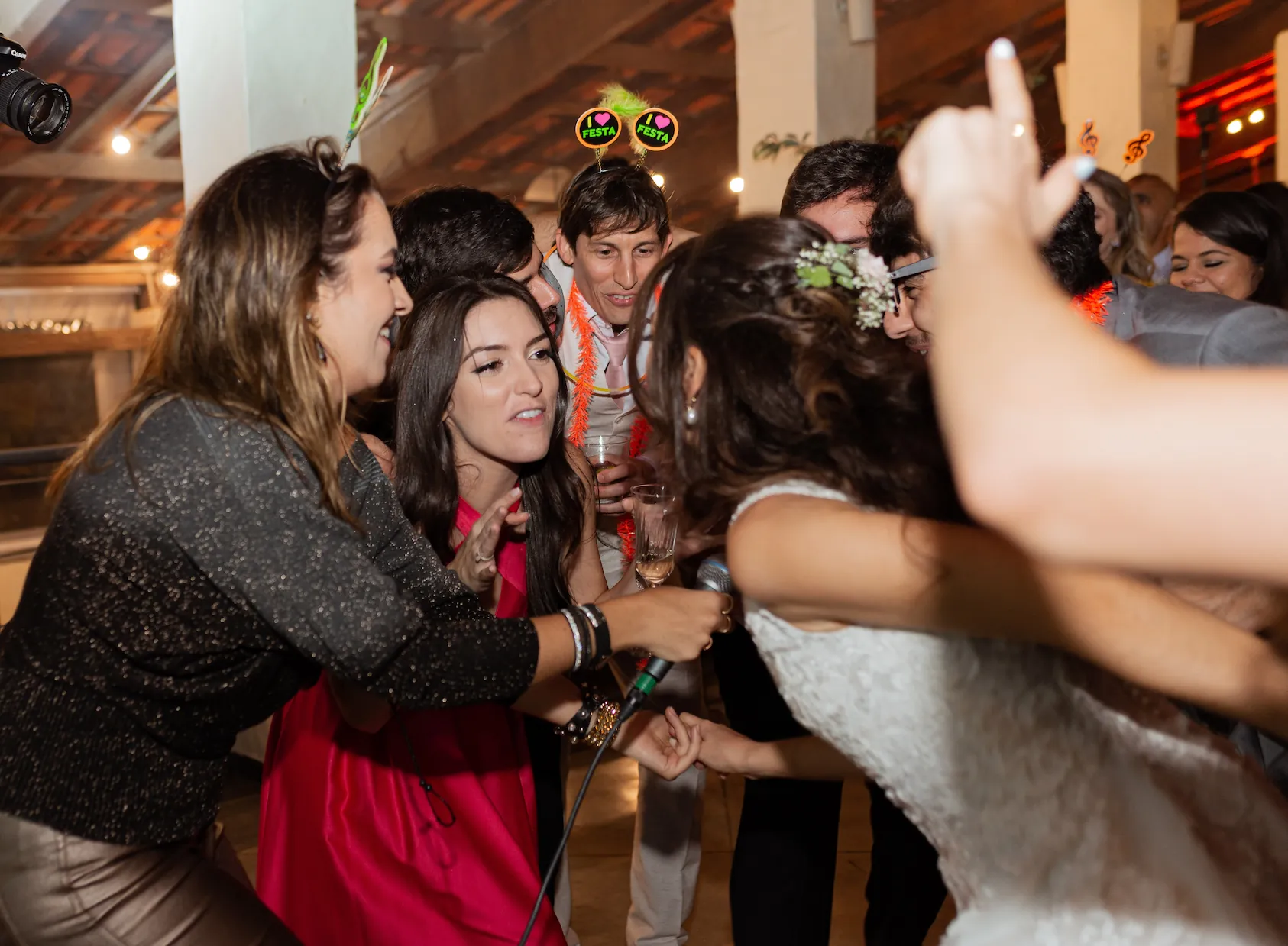 Vocalista da banda Barbie Kills animando convidados na pista de dança de um casamento, cantando Pop e Brasilidades com energia.