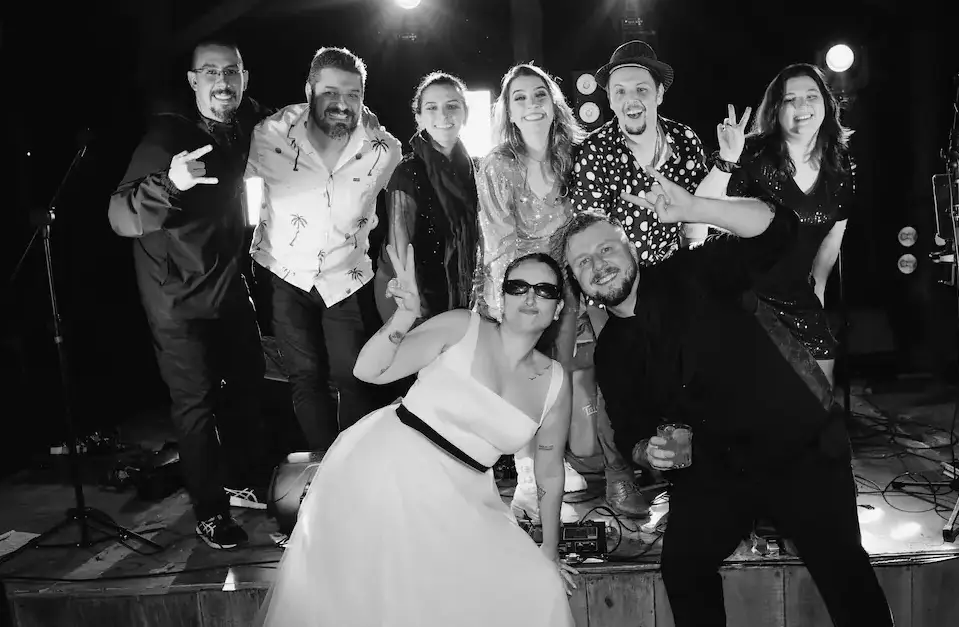 Noiva celebrando no palco com musicos da Banda Barbie Kills em casamento
